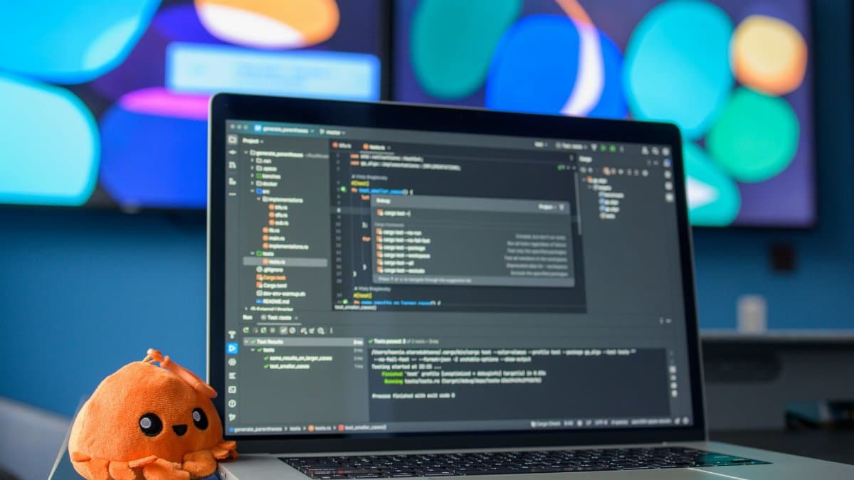 Colorful workspace featuring a laptop with code editor and vibrant screens.