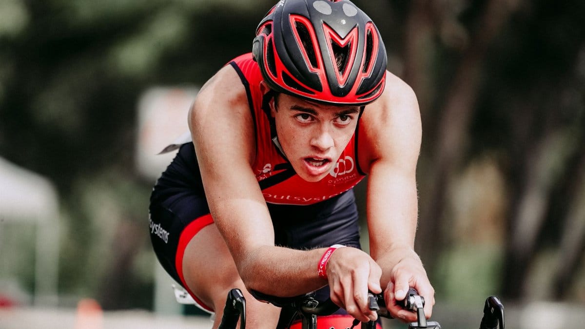 Focused man in helmet and sportswear cycling on track during marathon and looking straight