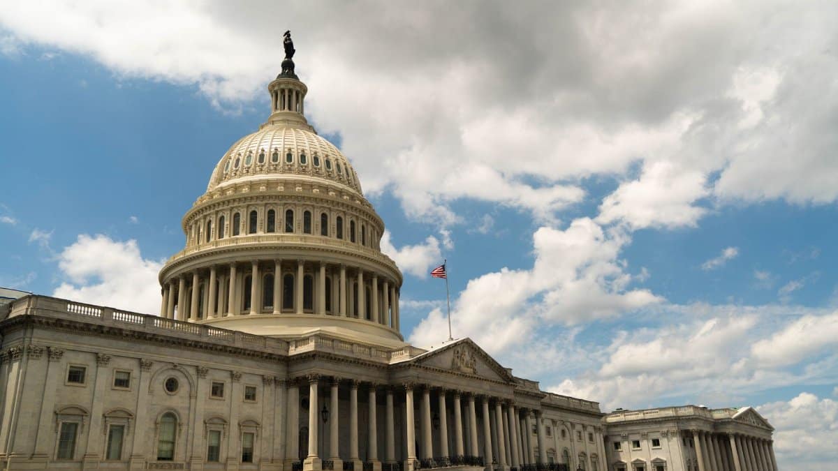The United States Capitol building dome against a blue sky in Washington, DC, architectural landmark.