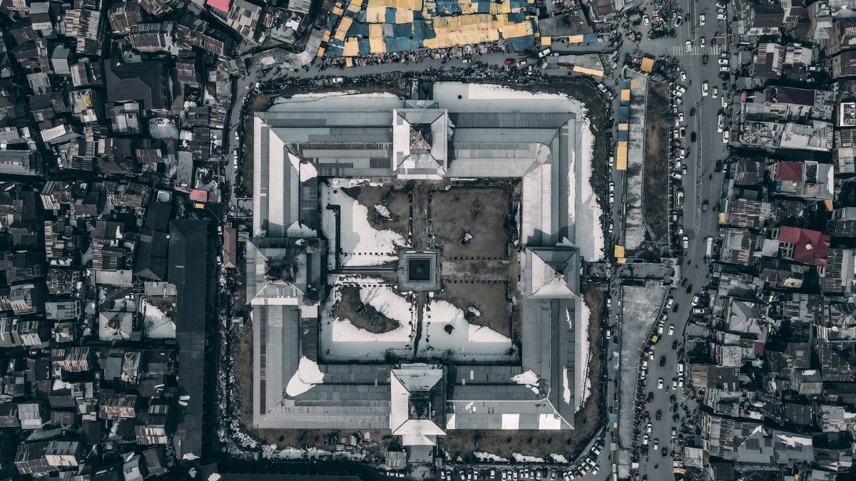 A stunning aerial view of an urban complex with a central courtyard and surrounding buildings.