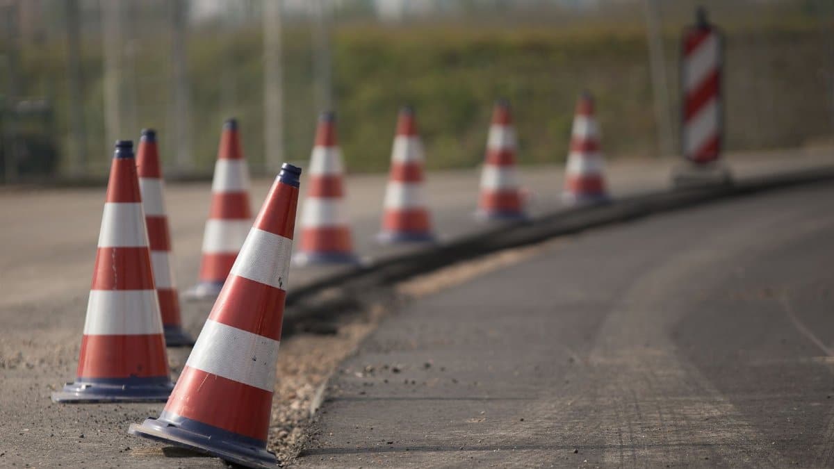 Line of traffic cones on a road under construction, indicating warning and caution.