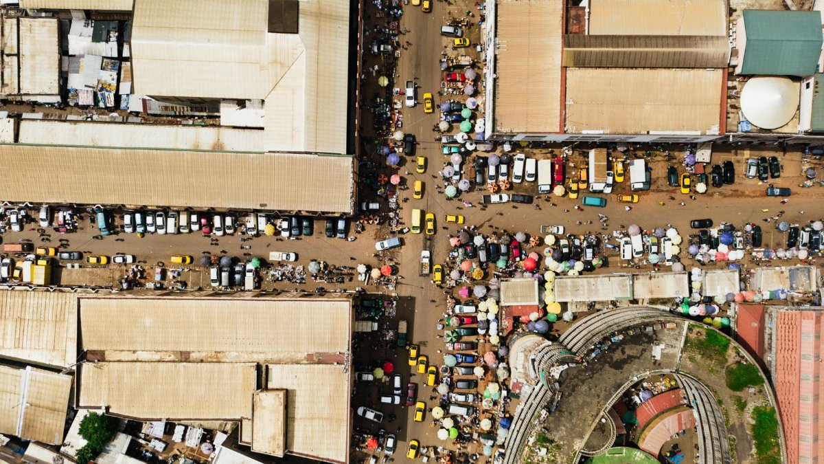 A bustling market street in Yaoundé, Cameroon, captured from above showing vibrant city life and architecture.
