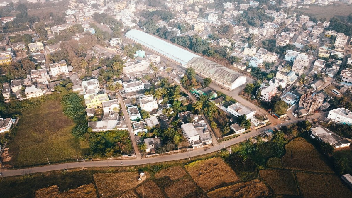 Aerial shot of Keonjhar, Odisha, showcasing fields, rooftops, and urban landscape.