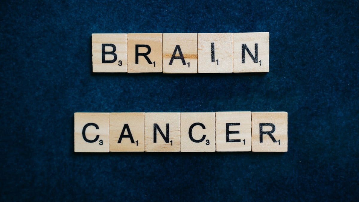 Wooden tiles spelling 'Brain Cancer' on a dark blue background, symbolizing awareness.