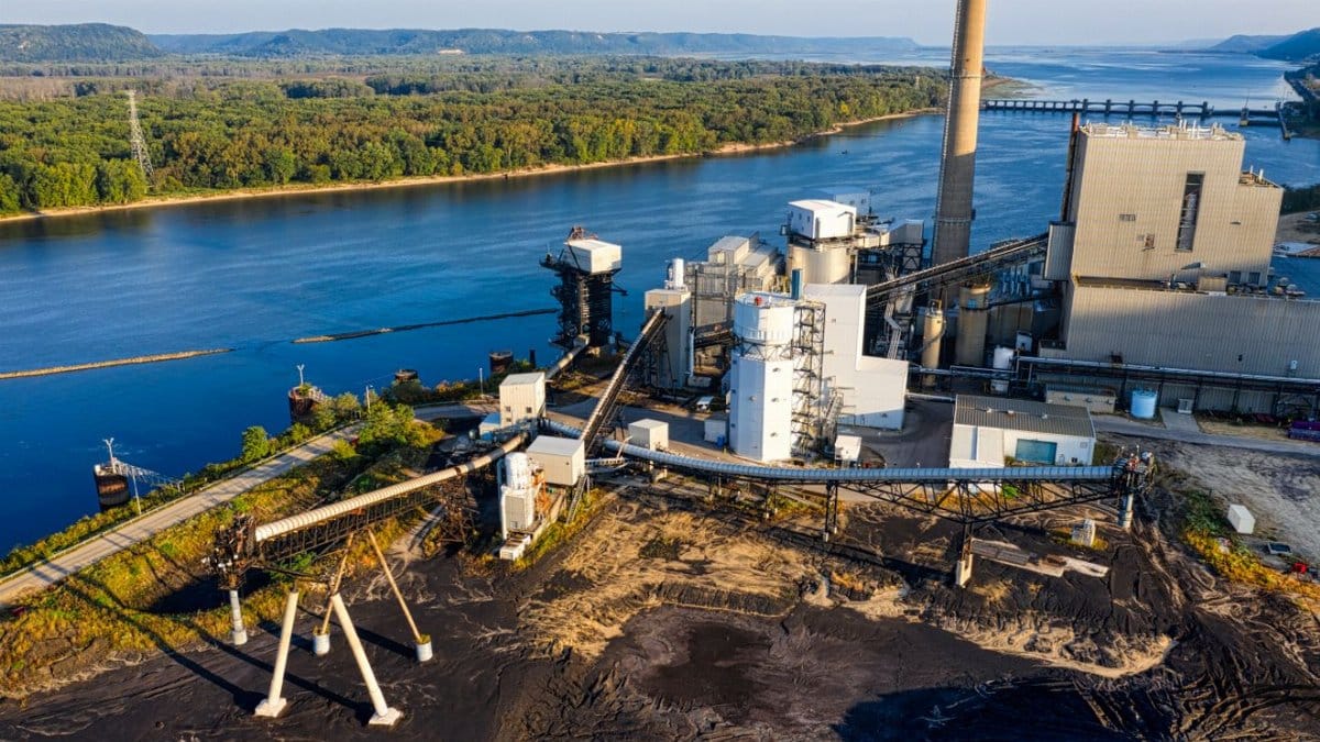 Aerial shot of a riverside industrial plant in Genoa, Wisconsin, showcasing environmental impact.