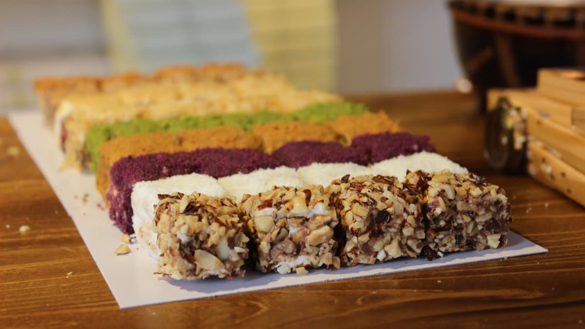 Vibrant array of Turkish desserts featuring nuts and colorful coatings on a wooden table in Karabük, Türkiye.