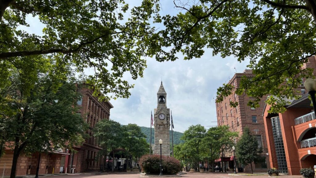 Charming view of historic Wellsboro courthouse square surrounded by lush trees on a summer day.