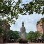 Charming view of historic Wellsboro courthouse square surrounded by lush trees on a summer day.