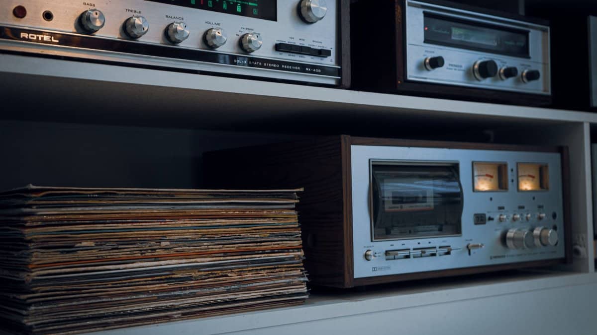 Retro audio setup featuring a vintage record player, tape deck, and classic stereo equipment alongside a stack of vinyl records.