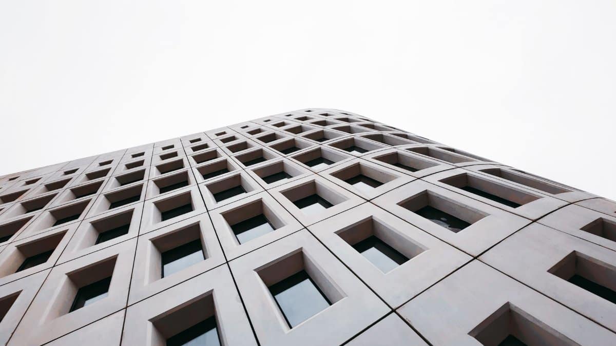 Dynamic low-angle shot of a modern building facade in Nanjing, highlighting geometric patterns and glass windows.