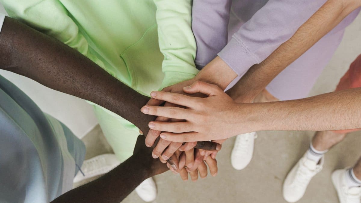 Top view of diverse hands stacked together, symbolizing unity and teamwork.