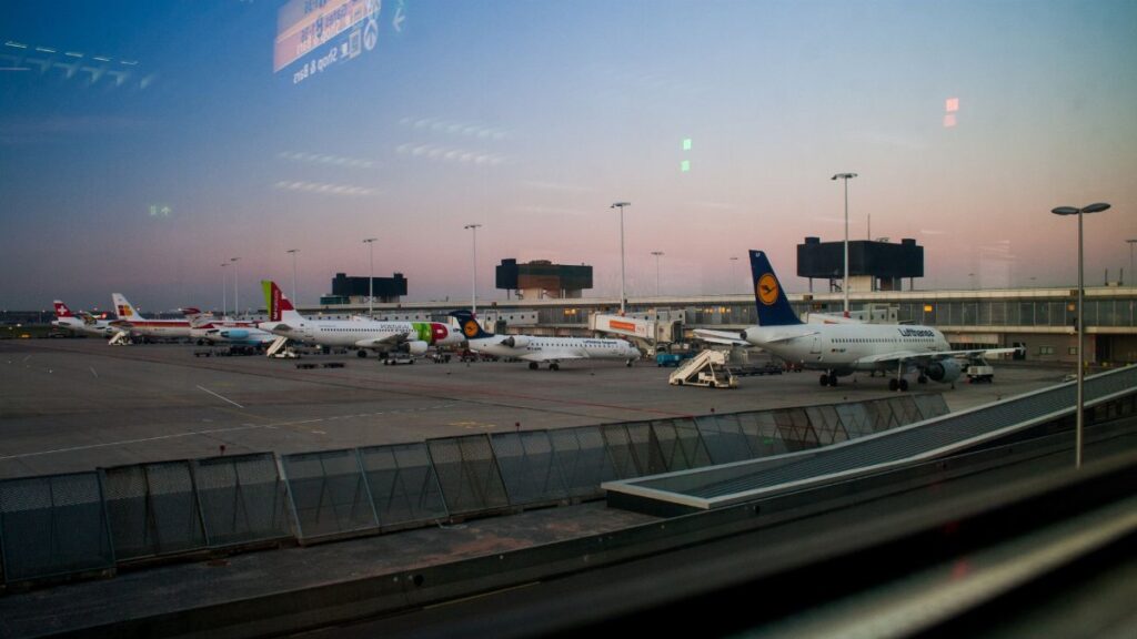 View of various airplanes parked at an airport during dusk, showcasing aviation.