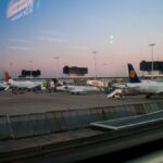 View of various airplanes parked at an airport during dusk, showcasing aviation.