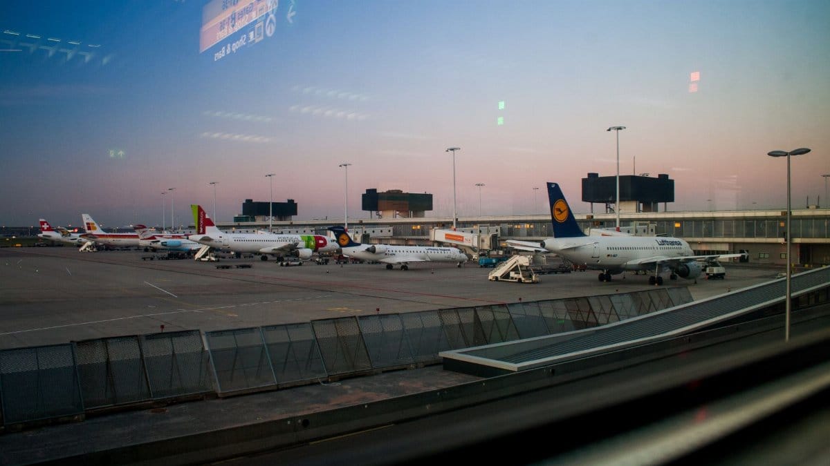 View of various airplanes parked at an airport during dusk, showcasing aviation.