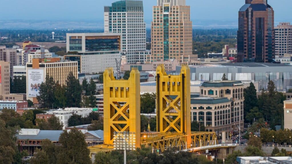 Dramatic aerial view capturing the iconic Tower Bridge and the striking skyline of Sacramento, California at day.