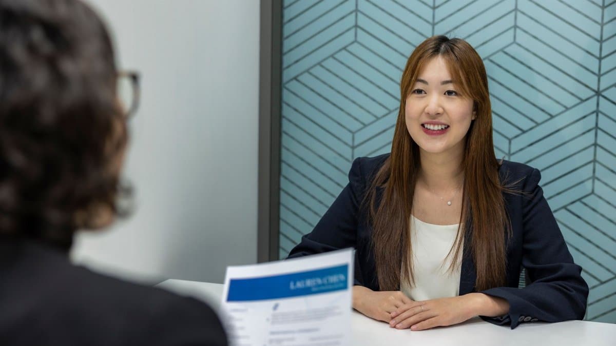 Young woman in a business meeting with an interviewer, showcasing confidence and professionalism.