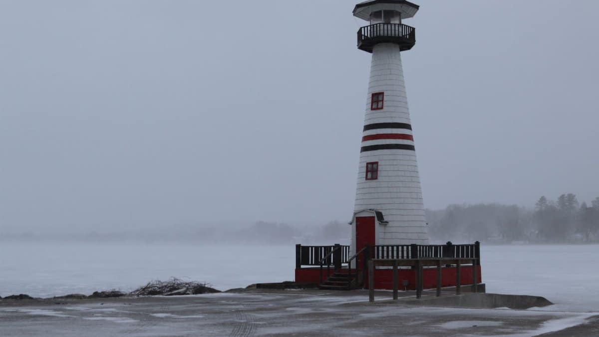 Snow-covered lighthouse by Chautauqua Lake, New York in winter.