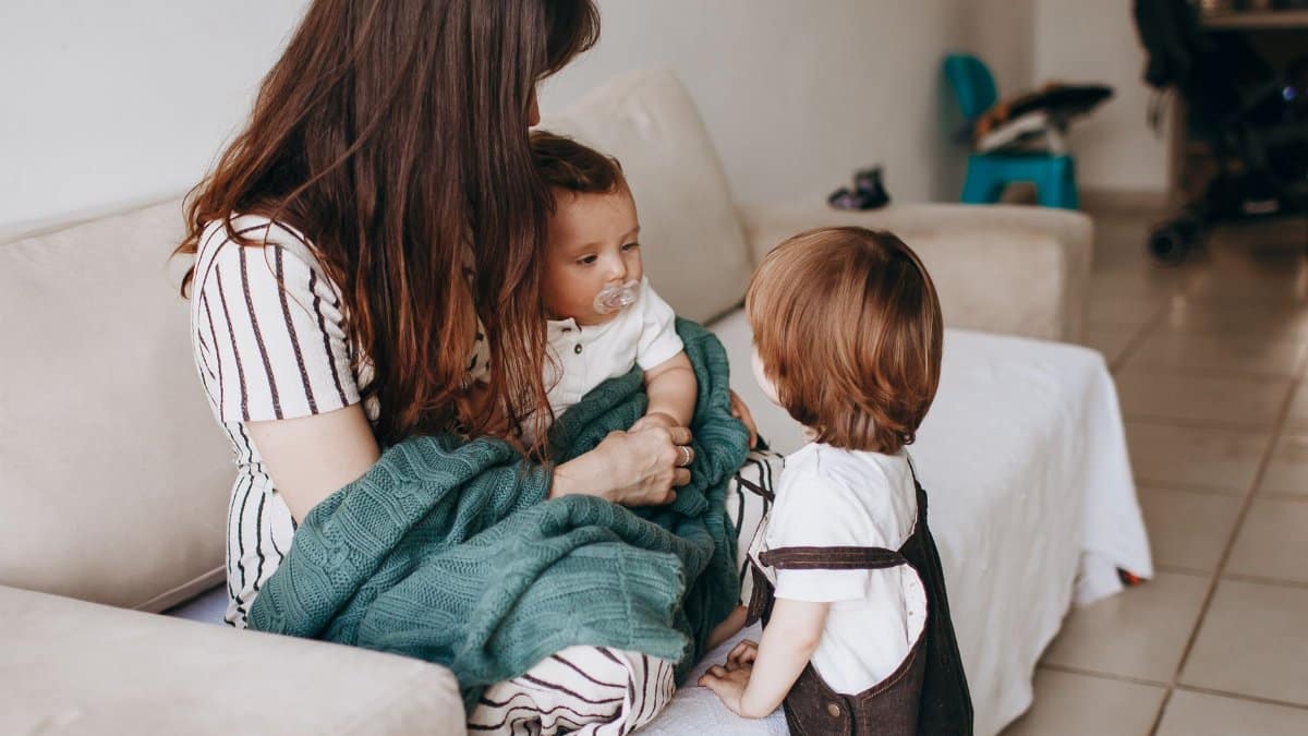 Mother and children share a warm moment on the sofa, filled with love and togetherness.