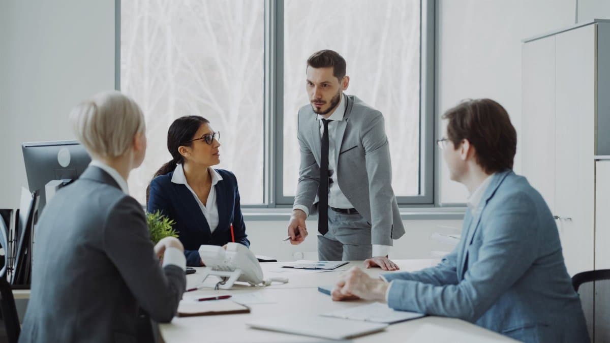 Professionals engaged in a serious business discussion in a bright office environment.