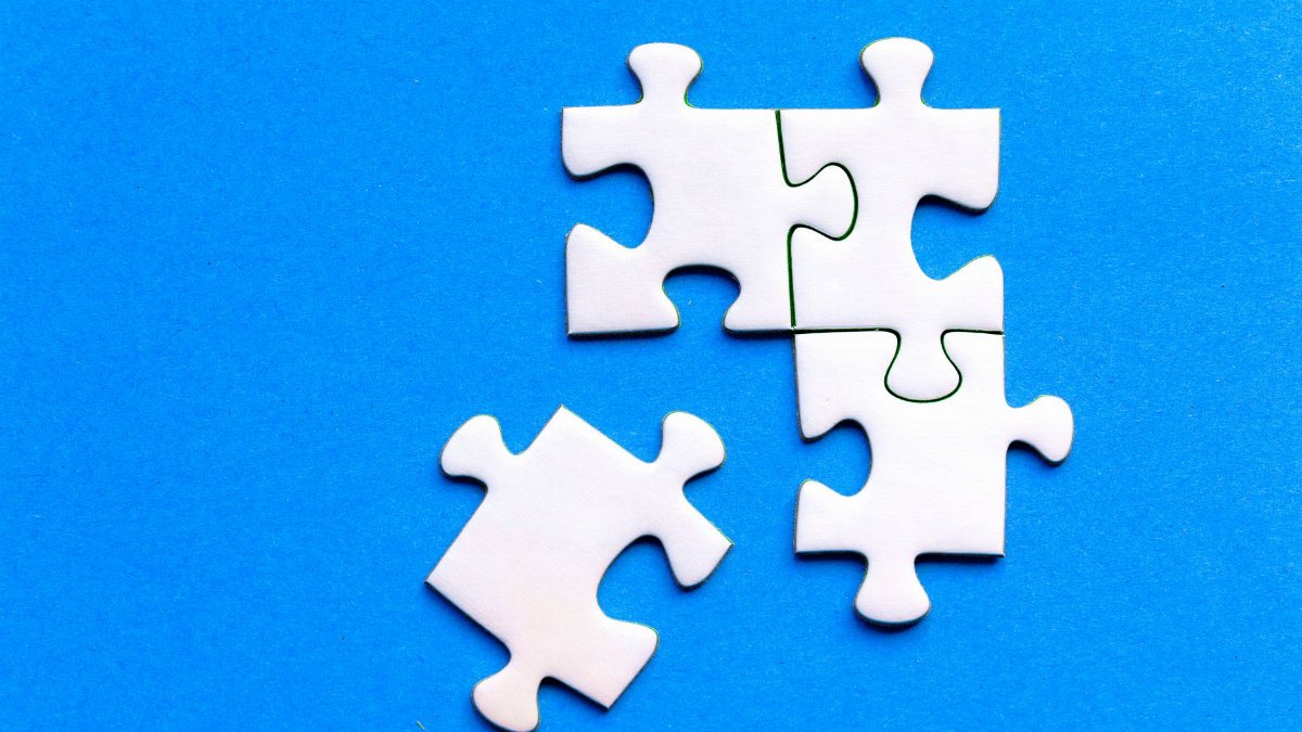 White jigsaw puzzle pieces against a solid blue background, showcasing a flat lay arrangement.