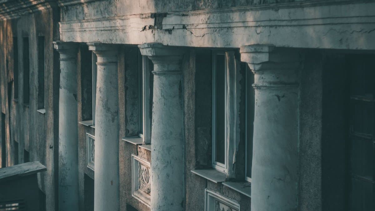 Aged facade of a classical building with ornate pillars and detailed architecture.