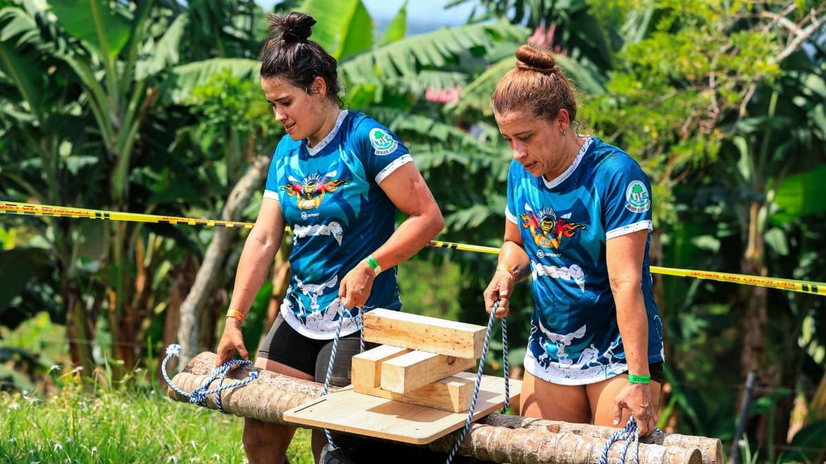 Two women participate in a competitive outdoor strength and endurance event.