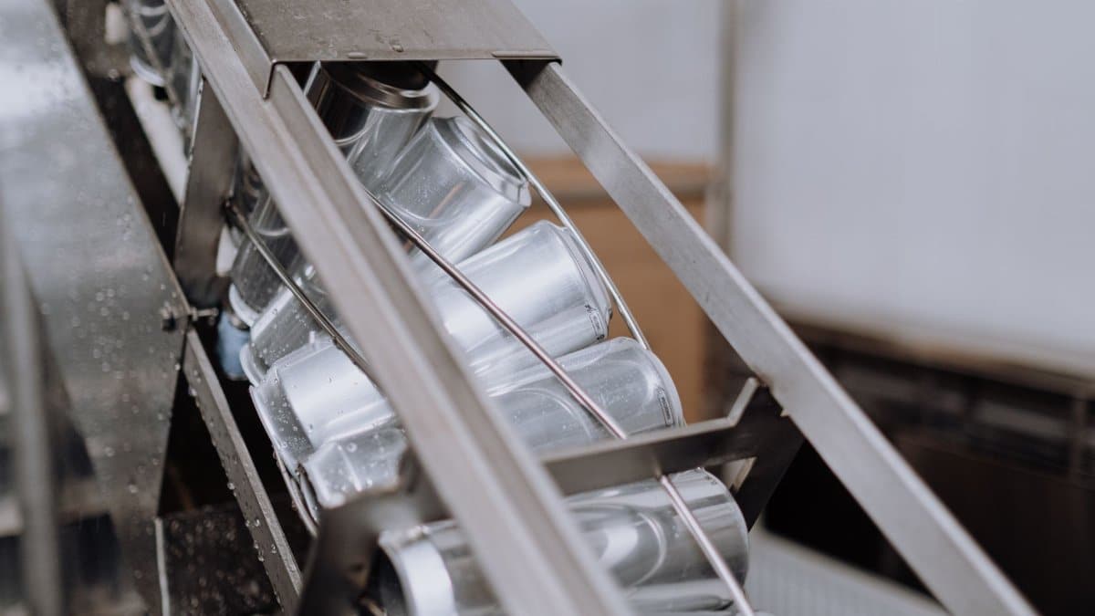 Close-up of automated canning equipment in a brewery showcasing production efficiency.