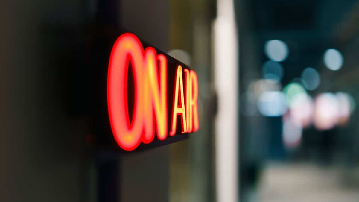Close-up of an illuminated 'On Air' sign symbolizing live broadcasting in a studio.
