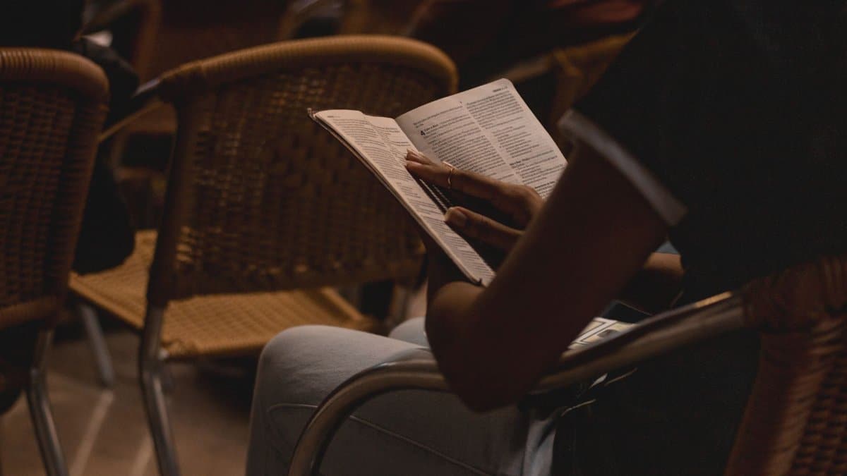 Person reading a book in a dimly lit room, creating a warm and intimate atmosphere.