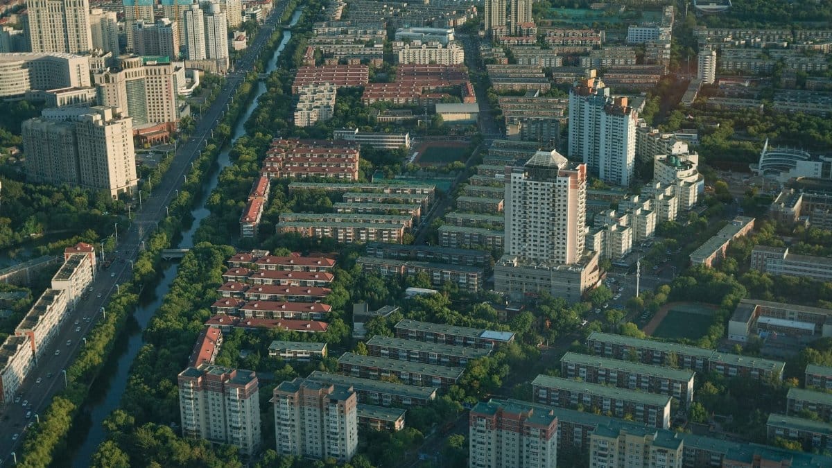 Aerial view of a modern city showcasing buildings and greenery under daylight.