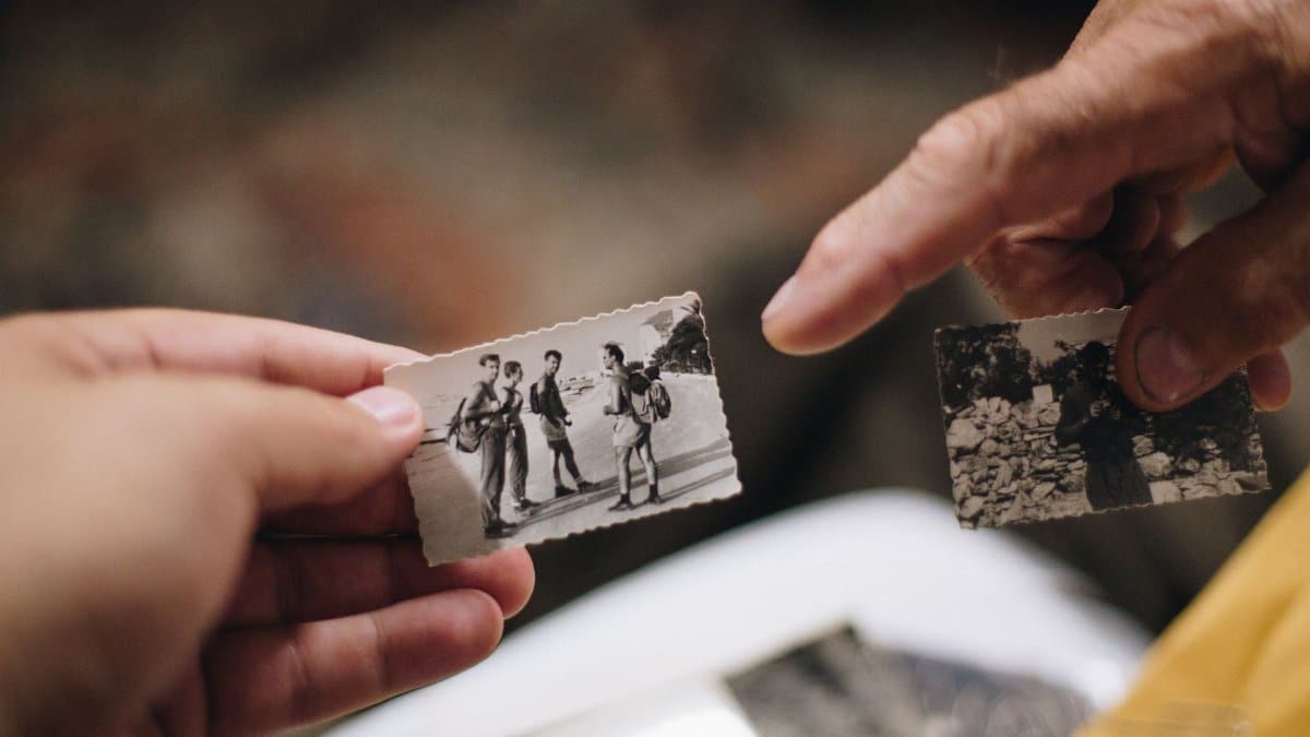 Close-up of hands holding vintage black and white photos, evoking nostalgia and memories.