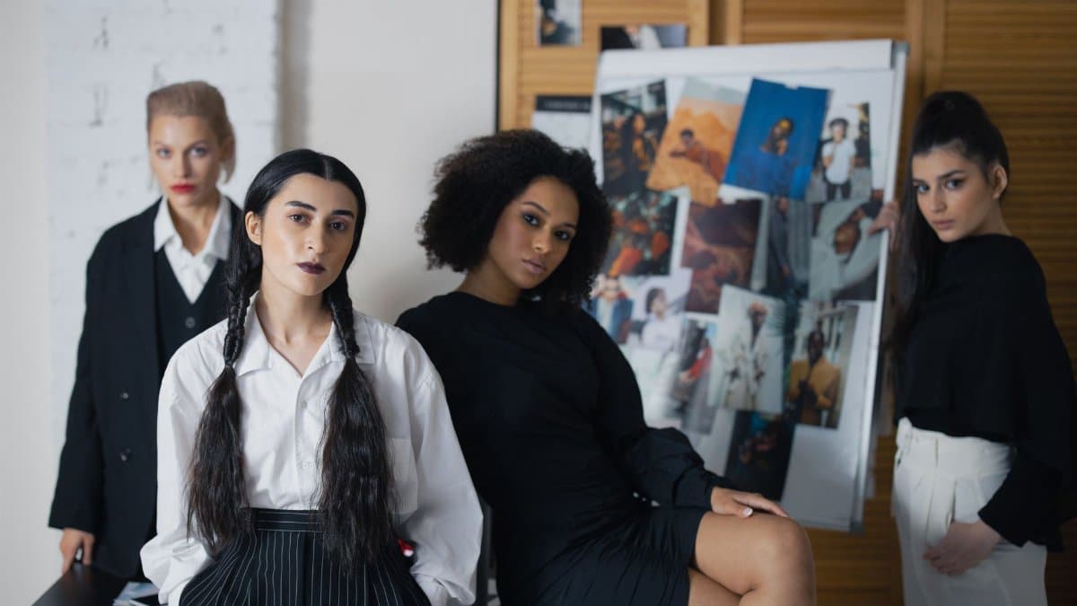 Diverse group of women displaying strength and style in a fashion studio setting.