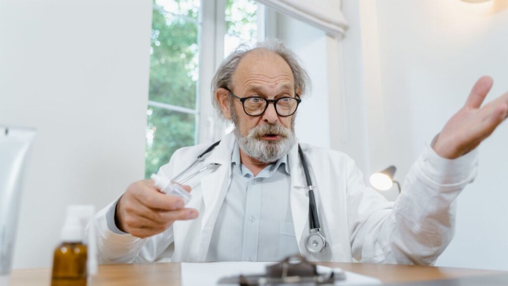 Senior doctor in discussion holding a syringe at a medical office, conveying expertise and care.