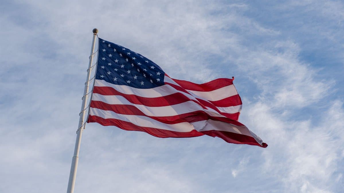 The American flag waves proudly against a backdrop of blue sky, symbolizing freedom and patriotism.