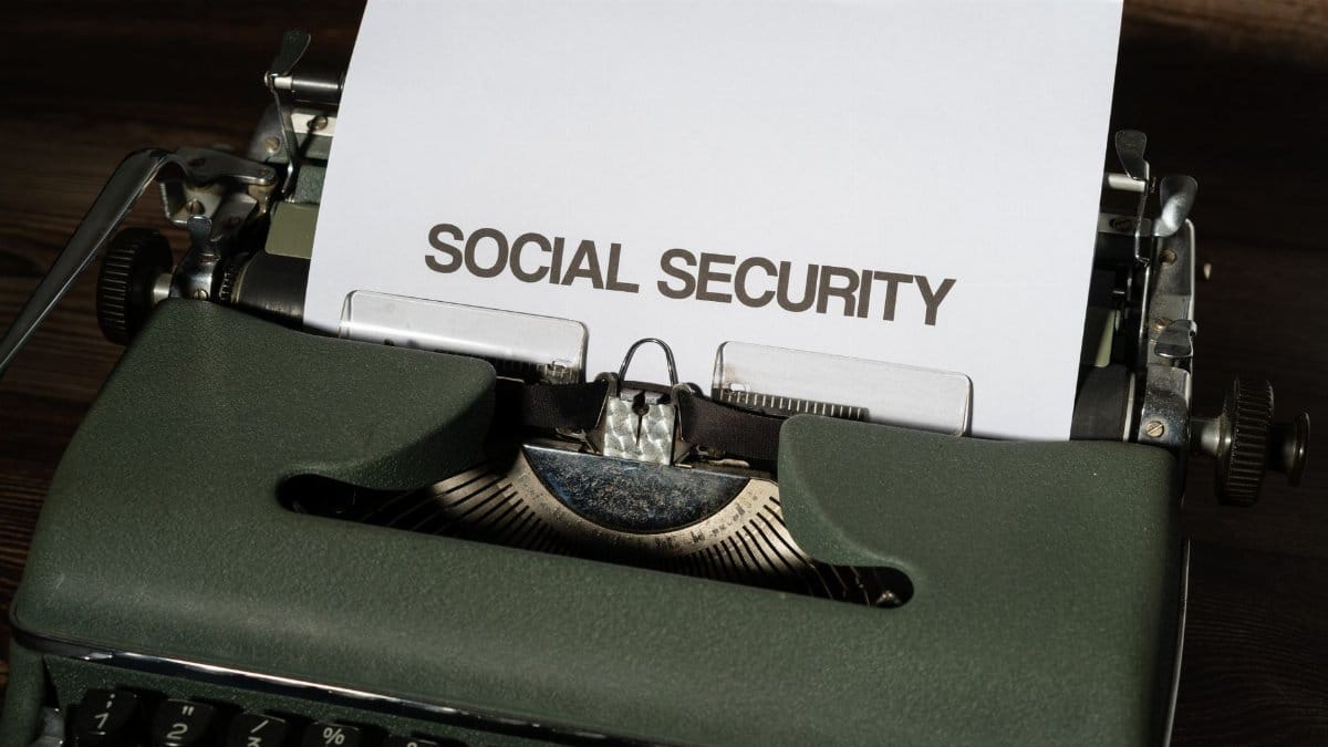Close-up of a vintage typewriter typing 'SOCIAL SECURITY' on paper, classic concept.