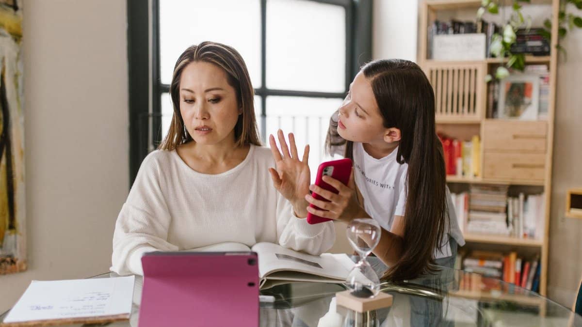 A mother and daughter interact with technology while at home, showcasing family dynamics.