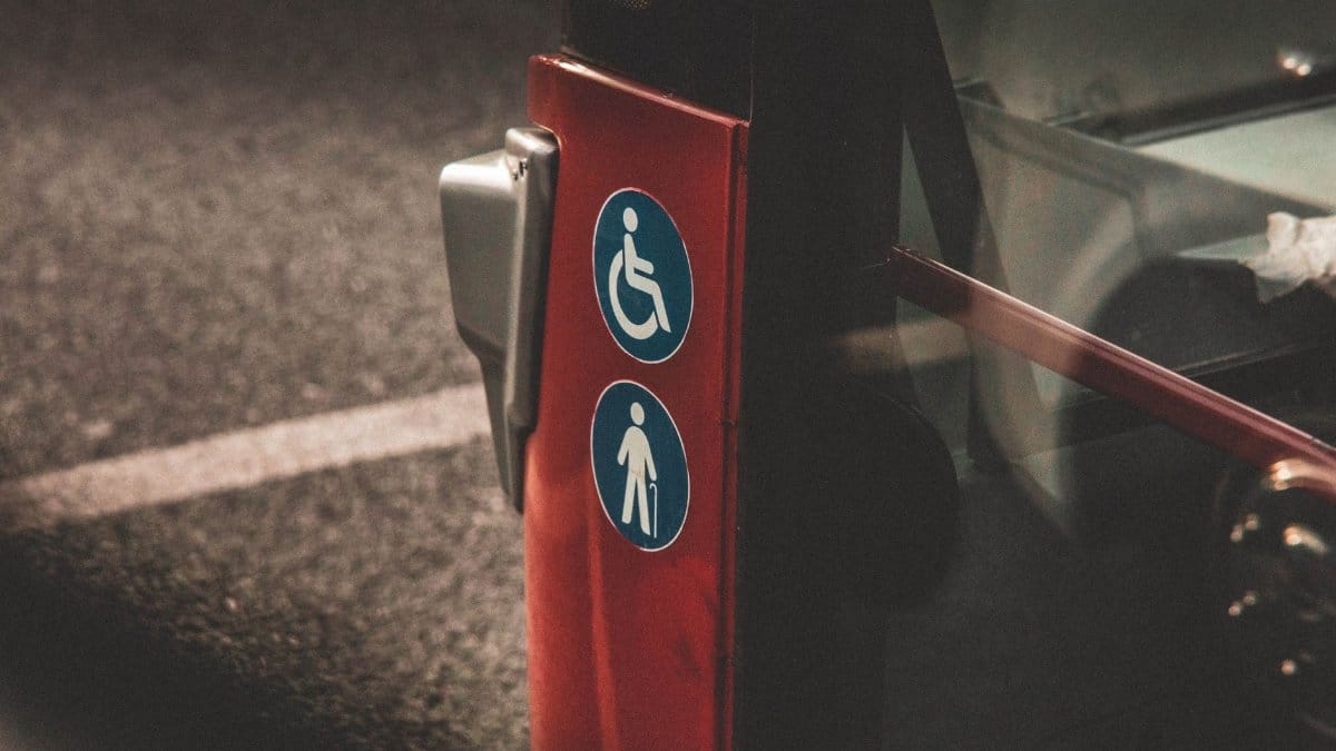 Close-up view of accessibility and elderly symbols on a red city bus.