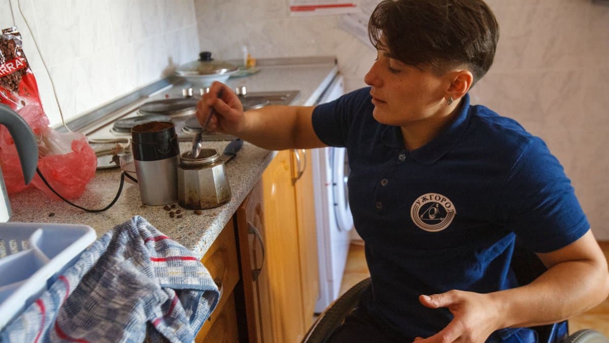 Individual in a wheelchair making coffee, showcasing independence and daily living.