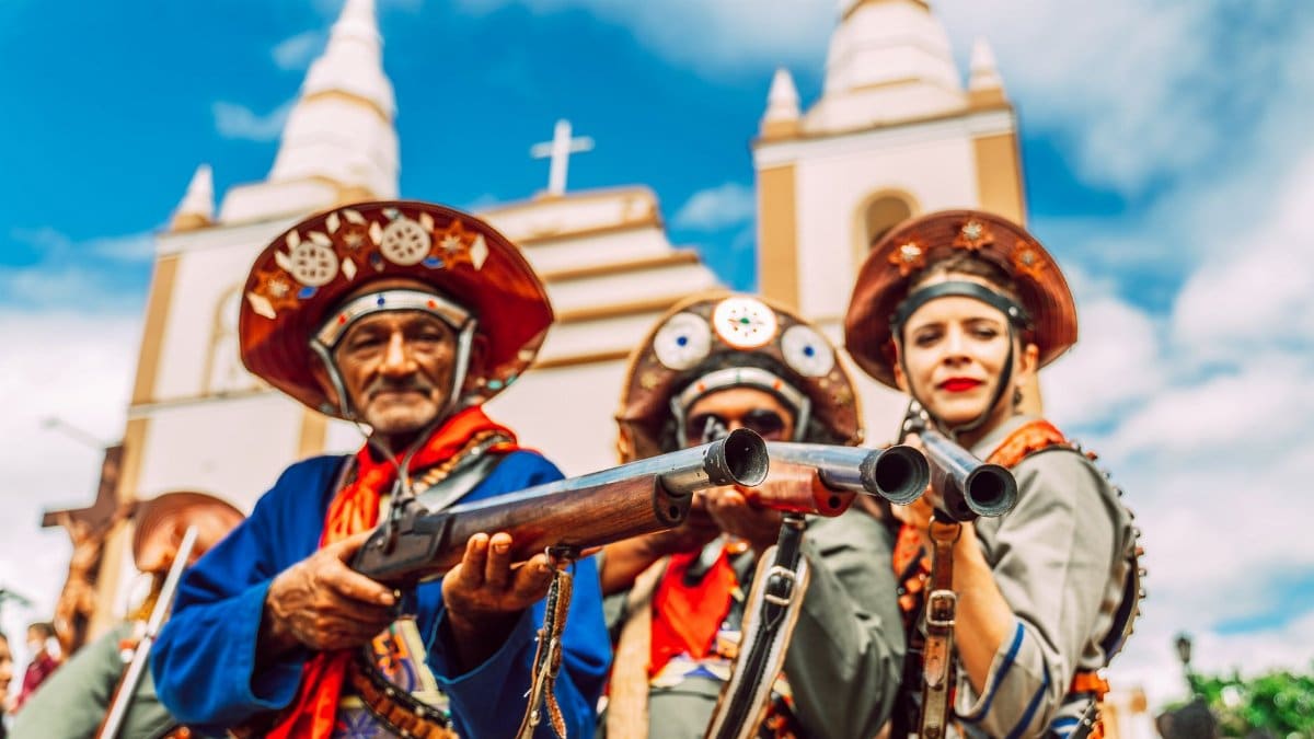 Colorful cultural parade featuring performers in traditional costumes in front of a historic church.
