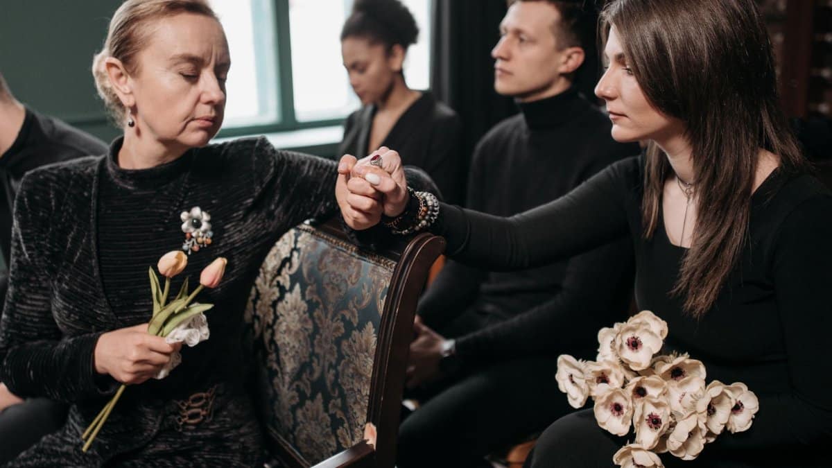 A somber family gathering indoors, displaying emotions of loss and support during a funeral.