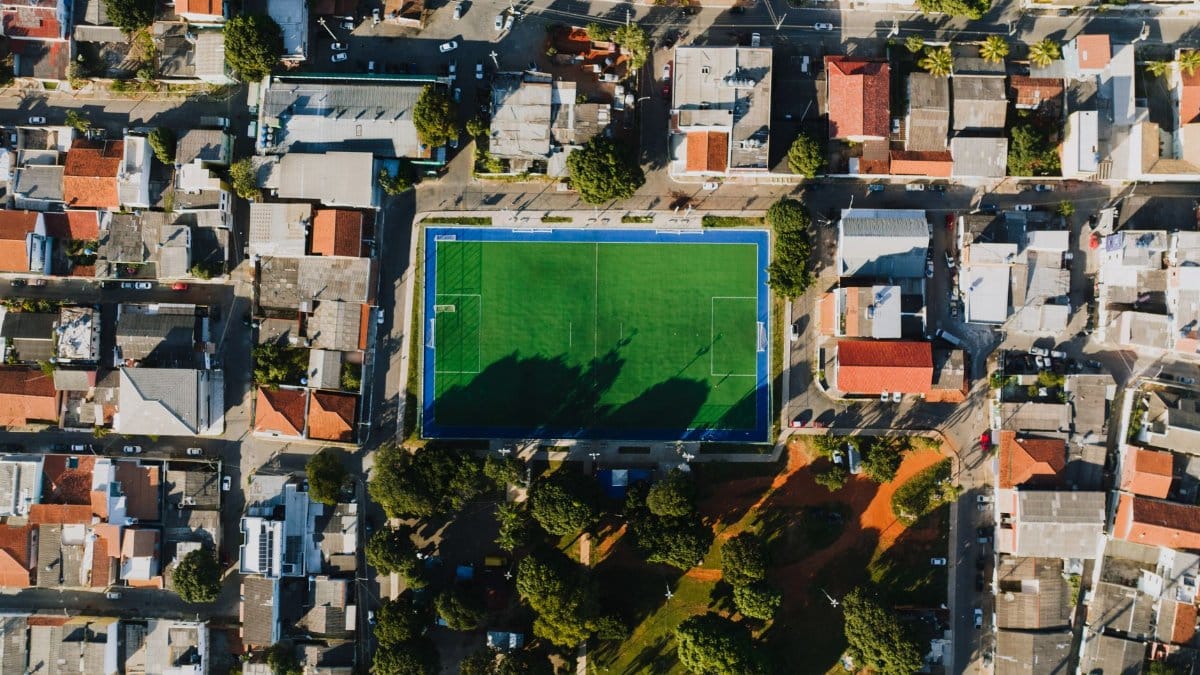 Drone shot of a soccer field in Vila Planalto, DF, Brazil surrounded by residential area.