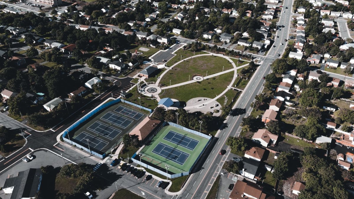 Aerial view showcasing a suburban area with tennis courts and green spaces.