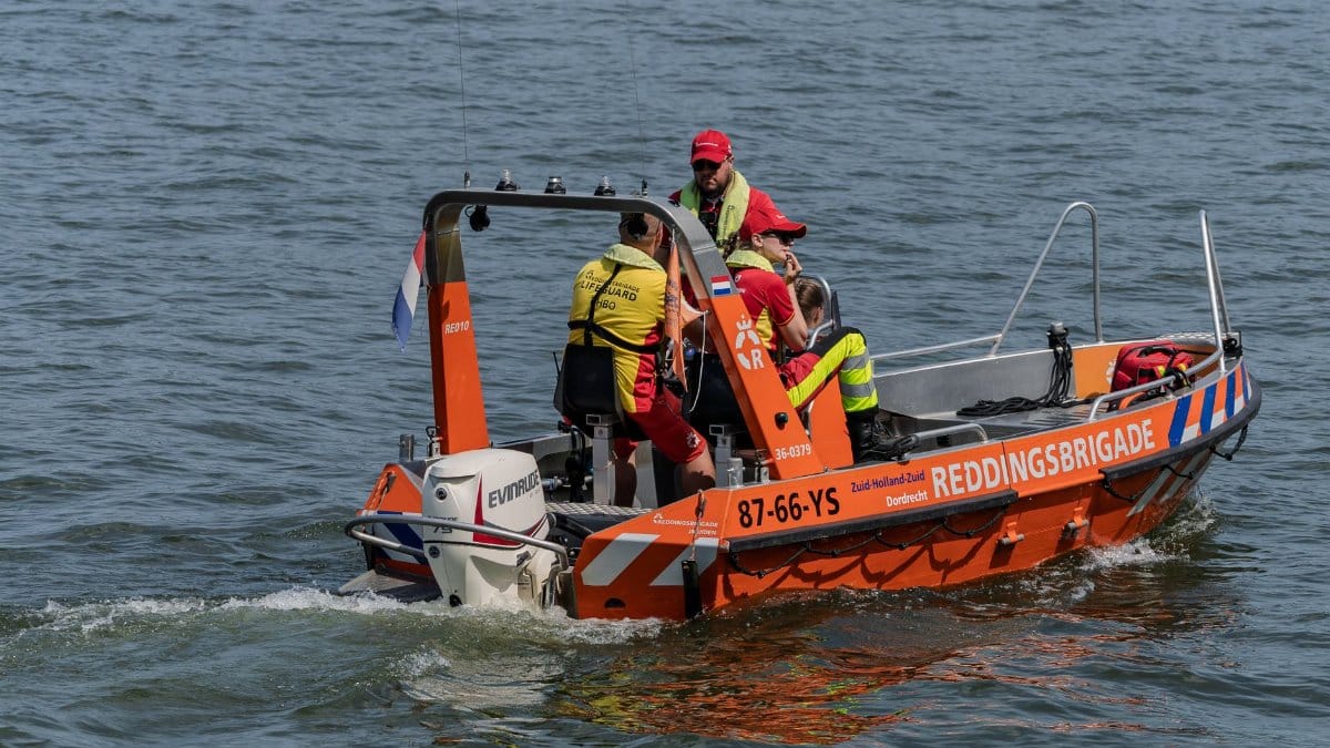 Lifeguards on a Reddingsbrigade boat patrolling water for safety and rescue operations.