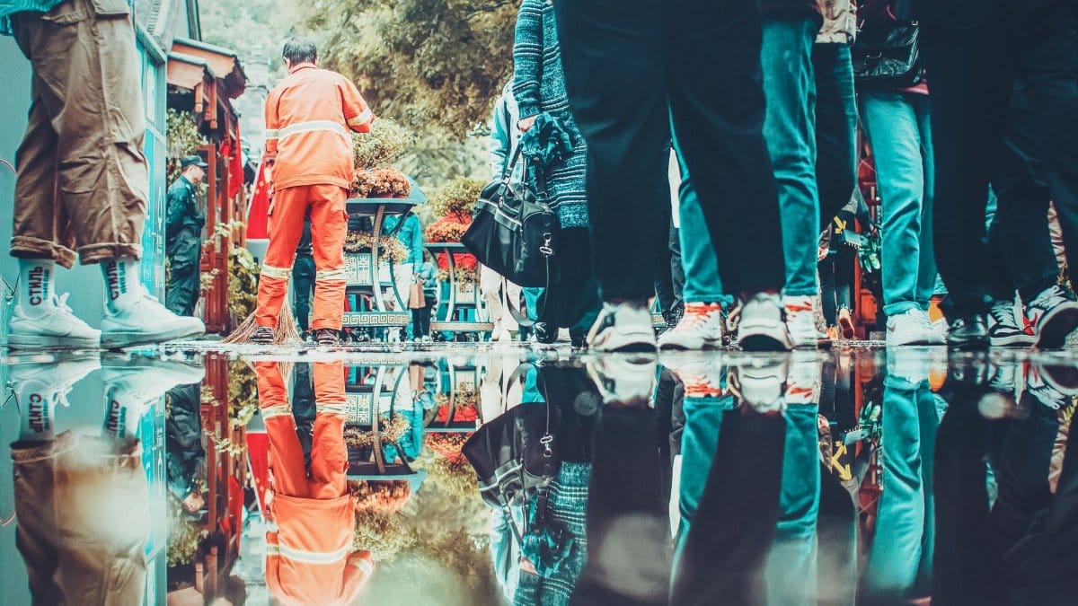 Vibrant street scene in Beijing market with reflections in puddles capturing people and colorful surroundings.