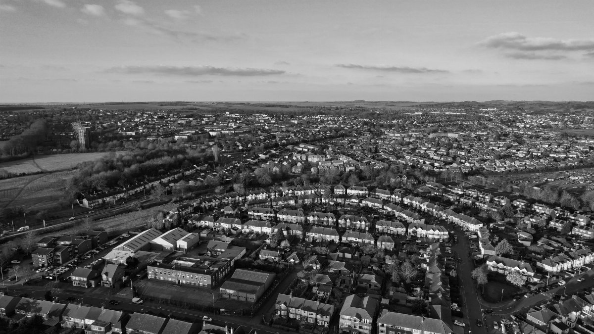 Black and white aerial cityscape of Luton, showcasing urban and residential architecture.