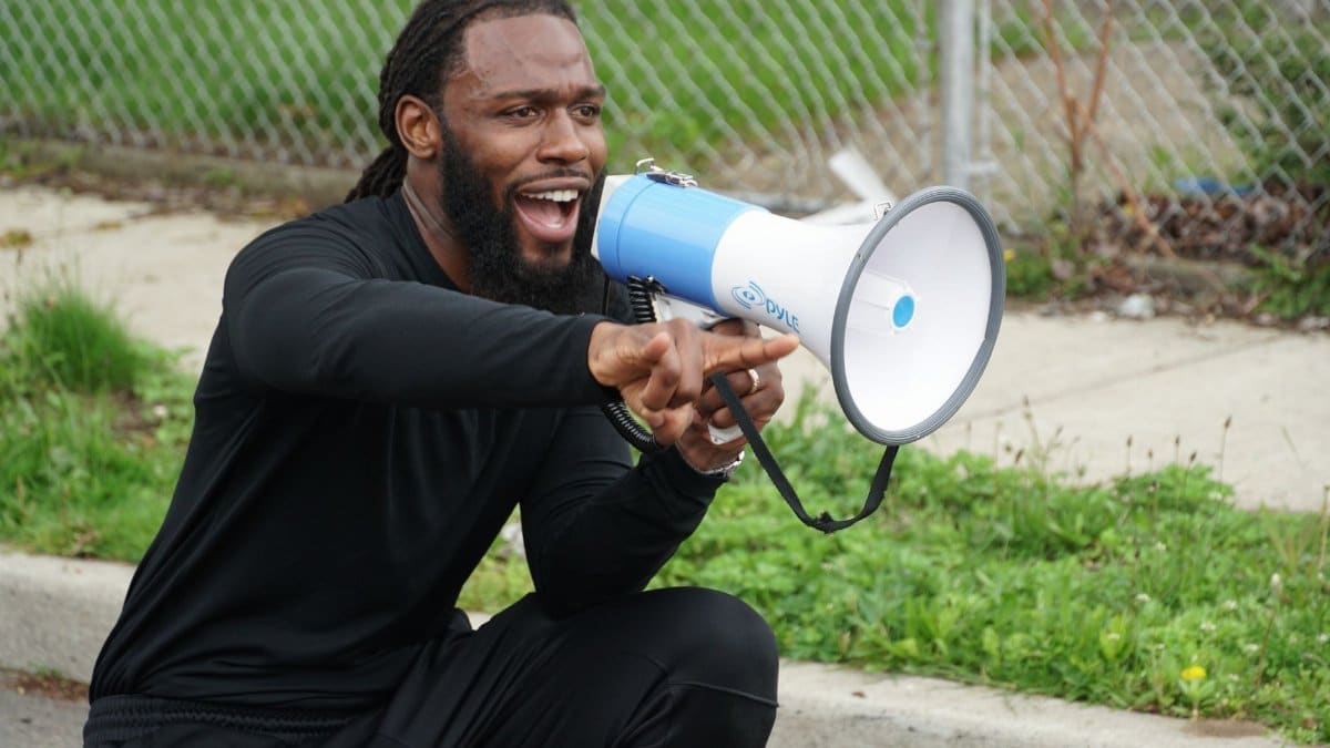 Energetic man using a megaphone to engage audience outdoors, New York.
