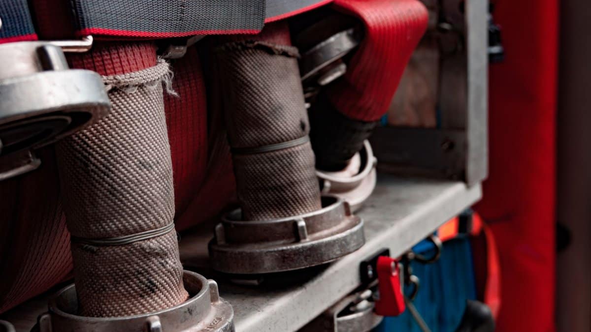 Close-up view of fire hoses coiled on a truck shelf, highlighting firefighting equipment.