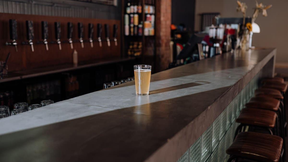 A refreshing glass of craft beer sits on a sleek bar counter, perfect for a modern pub setting.