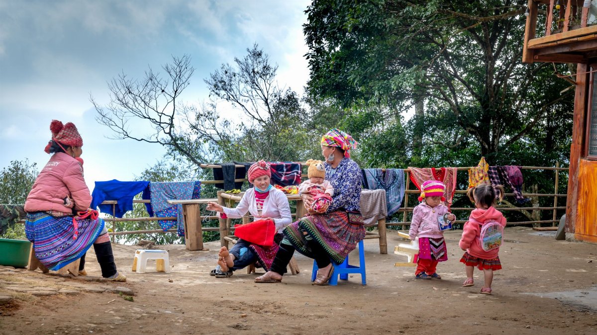 Family in traditional clothing enjoying outdoor time together in rural setting.