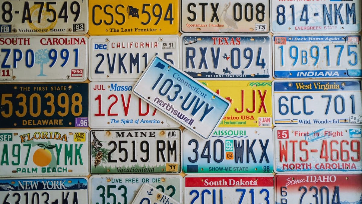 A colorful collage of vintage US license plates from various states on display.